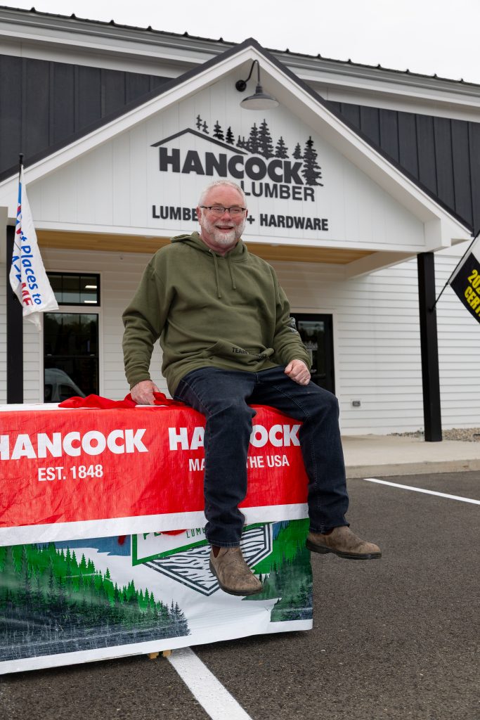Man on Lumber in front of store